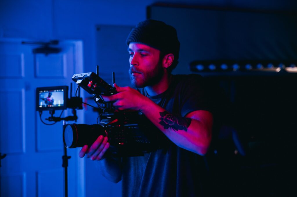 man in black t-shirt shooting music video ai holding video camera
